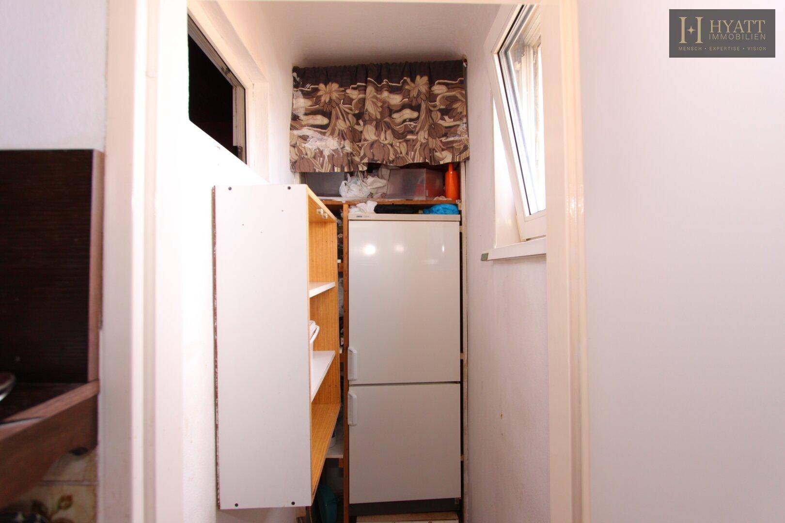 Kleiner Abstellraum mit Kühlschrank und Regalen für zusätzlichen Stauraum.