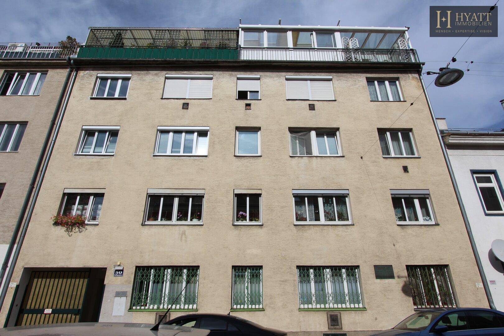 Mehrstöckiges Wohngebäude mit Balkonen und Fenstern in einer städtischen Umgebung.