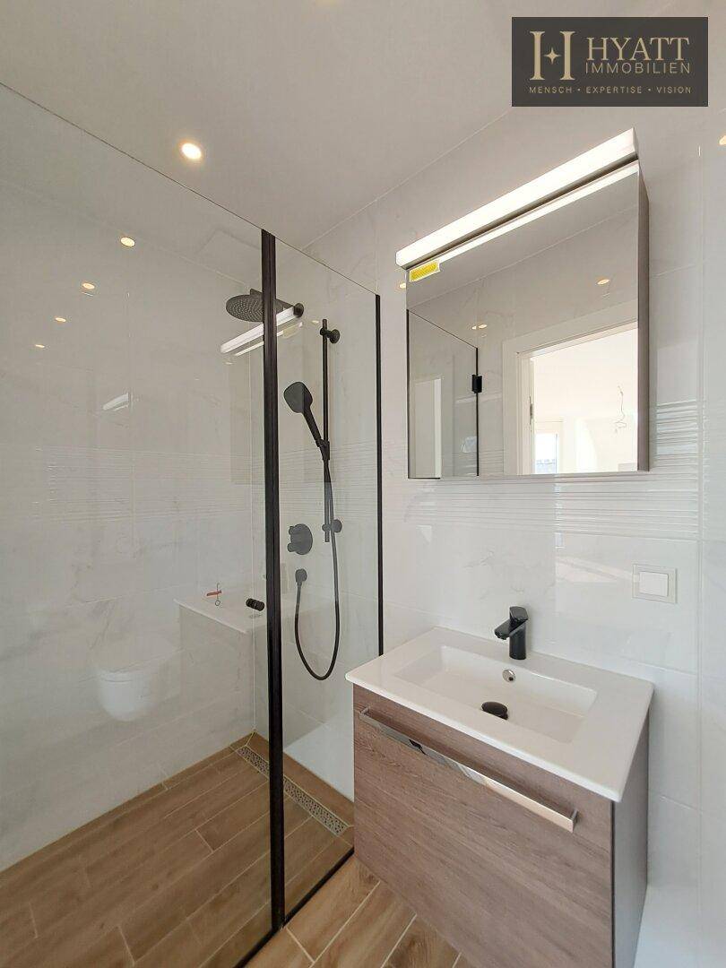 Modernes Badezimmer mit begehbarer Dusche, Waschtisch und weißen Fliesen.