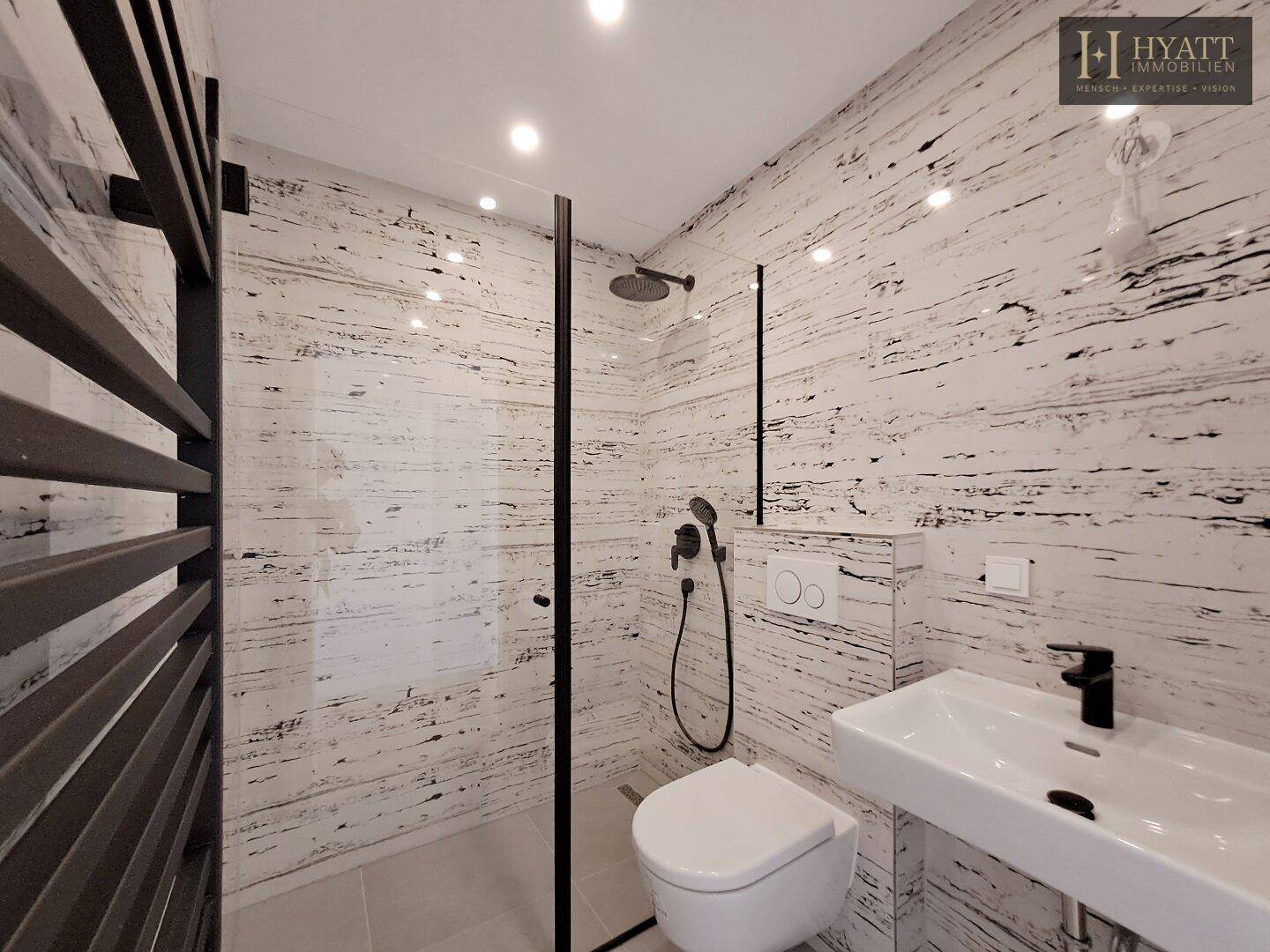 Modernes Badezimmer mit begehbarer Dusche, WC und stilvollen Fliesen.