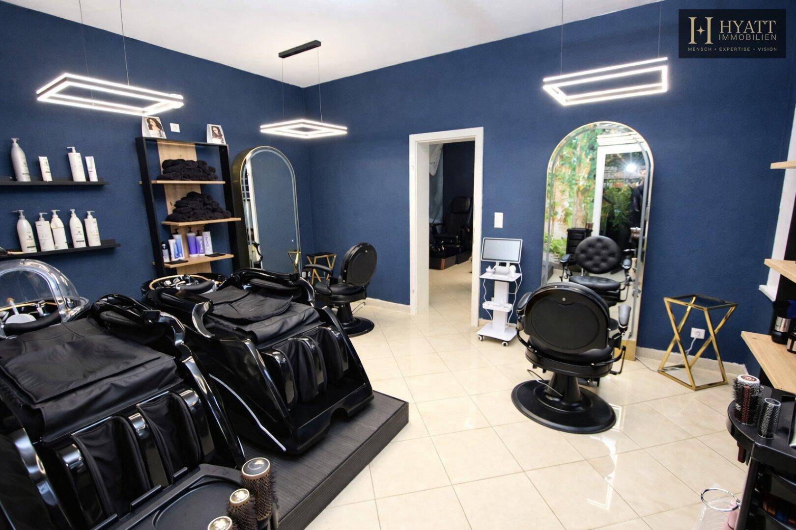 Moderner Friseur- und Spa-Bereich mit eleganten Bogen-Spiegeln, bequemen Stühlen und stilvoller Beleuchtung.