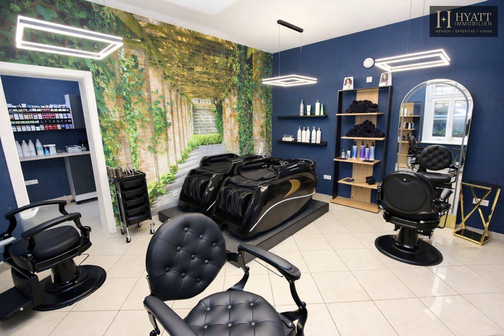 Geräumiger Schönheitssalon mit Spa-Liegen, Friseurstühlen und einer grünen Wandtapete mit Pflanzenmotiv.