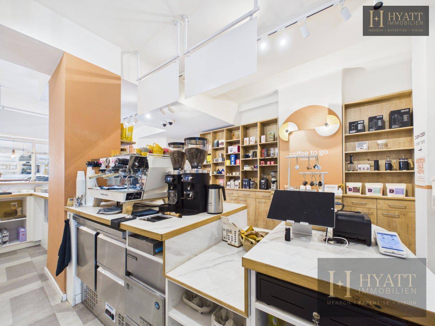 Kaffeestation mit professionellen Maschinen, Kassensystem und Marmorarbeitsplatte in einem Concept Store.