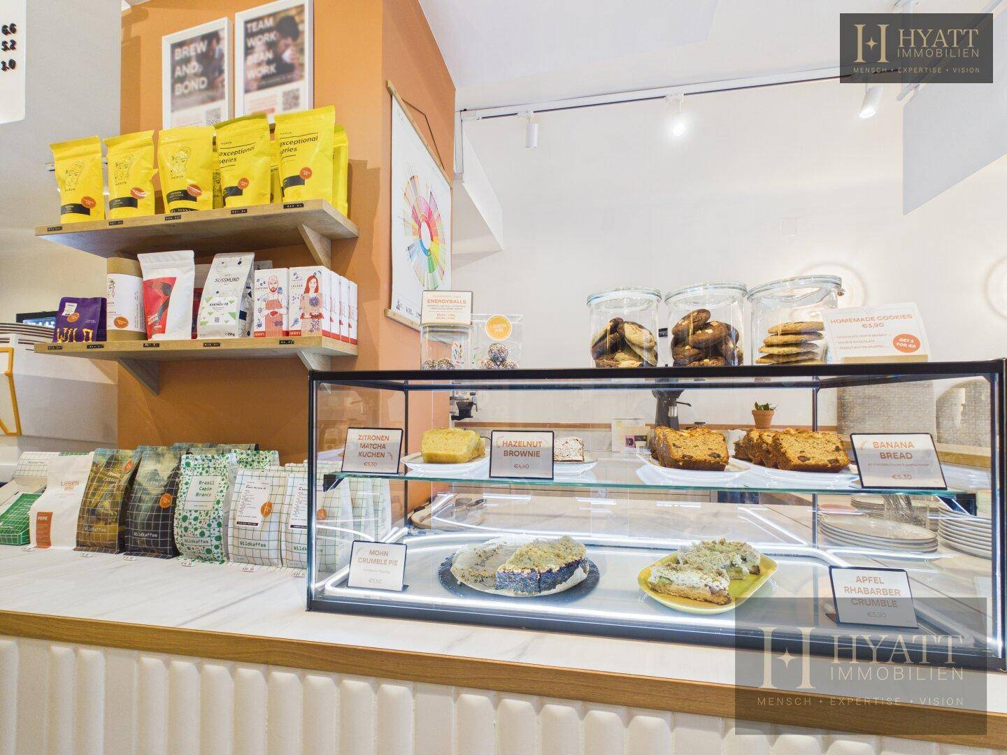 Kuchenvitrine mit verschiedenen Backwaren und Produkten in einem modernen Concept Store.
