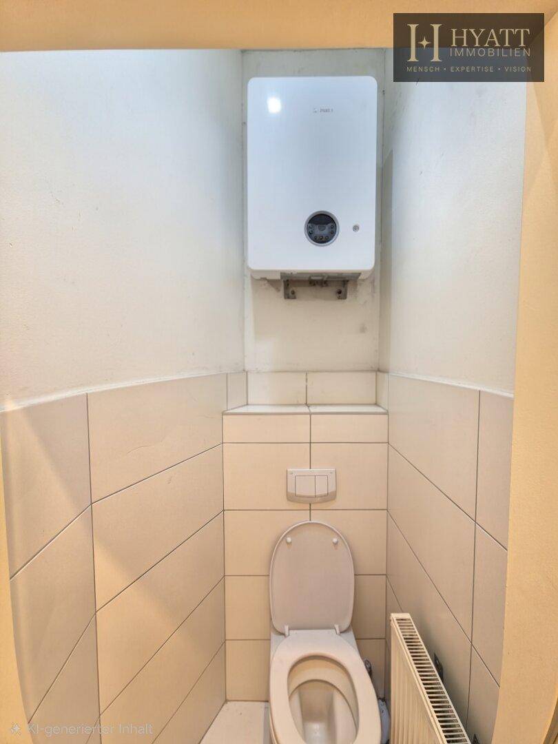 Separates WC mit Wandtoilette und Gastherme, gefliest und funktional gestaltet.