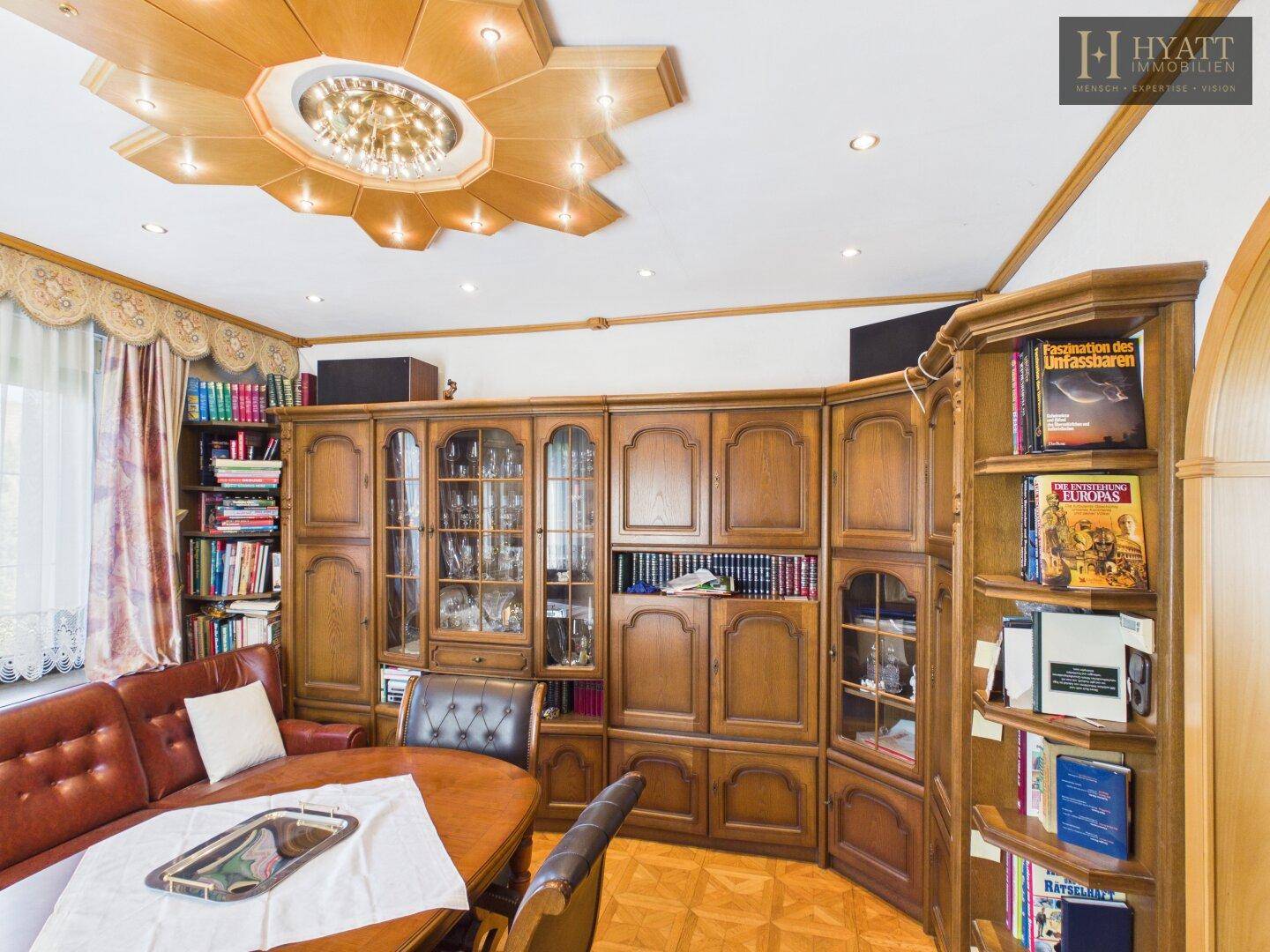 Wohn- und Essbereich mit umfangreicher Holzbibliothek und gemütlicher Sitzecke.