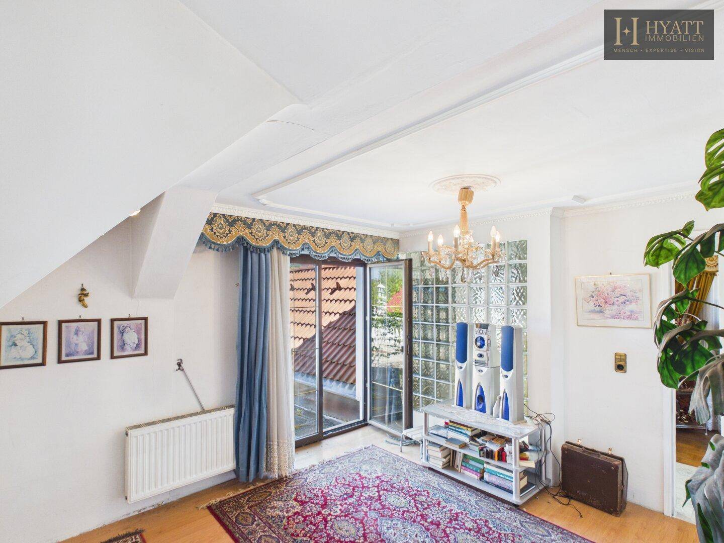 Helles Zimmer mit Zugang zu einem Balkon und Blick auf die Umgebung.