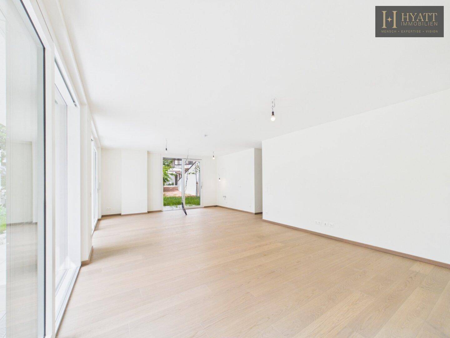 Geräumiges, helles Wohnzimmer mit großen Fenstern und Zugang zum Garten.