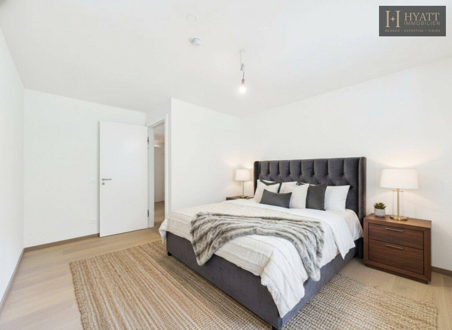 Gemütliches Schlafzimmer mit großem Doppelbett, Holzboden und modernem Teppich.