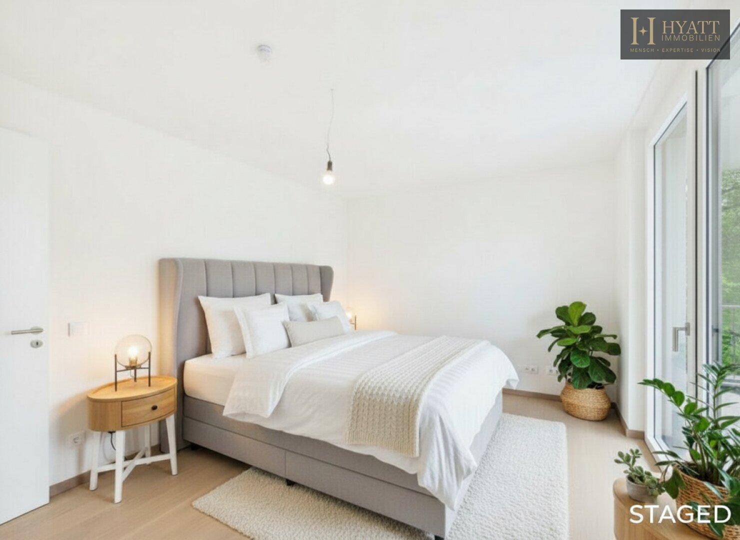 Modernes Schlafzimmer mit großem Bett, Holzboden und Zugang zu einem hellen Außenbereich.