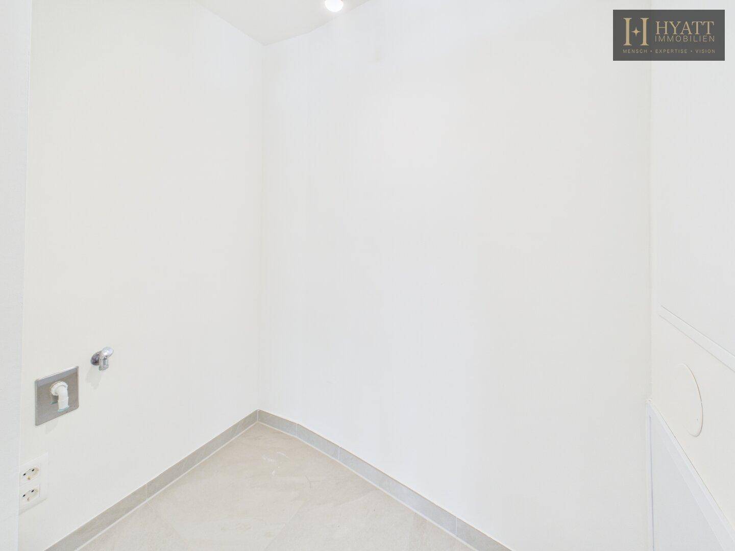 Leerer Hauswirtschaftsraum mit Anschlüssen, ideal für Waschmaschine und Trockner.
