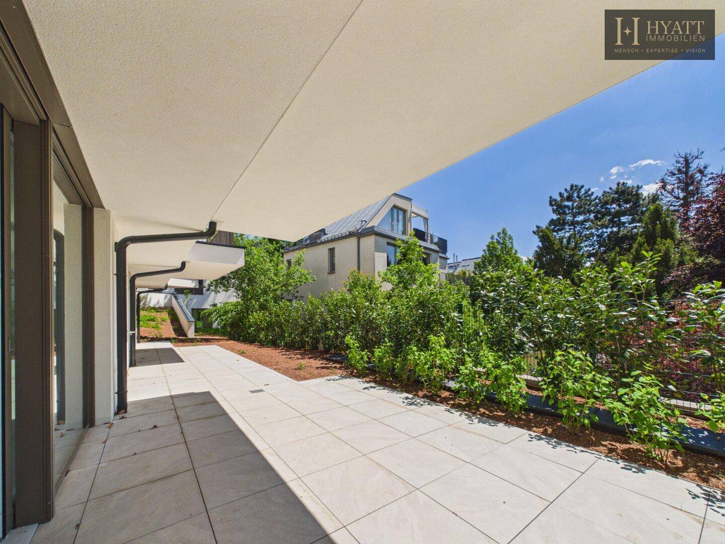 Geräumige, überdachte Terrasse mit Fliesenboden, ideal für entspannte Stunden im Freien.