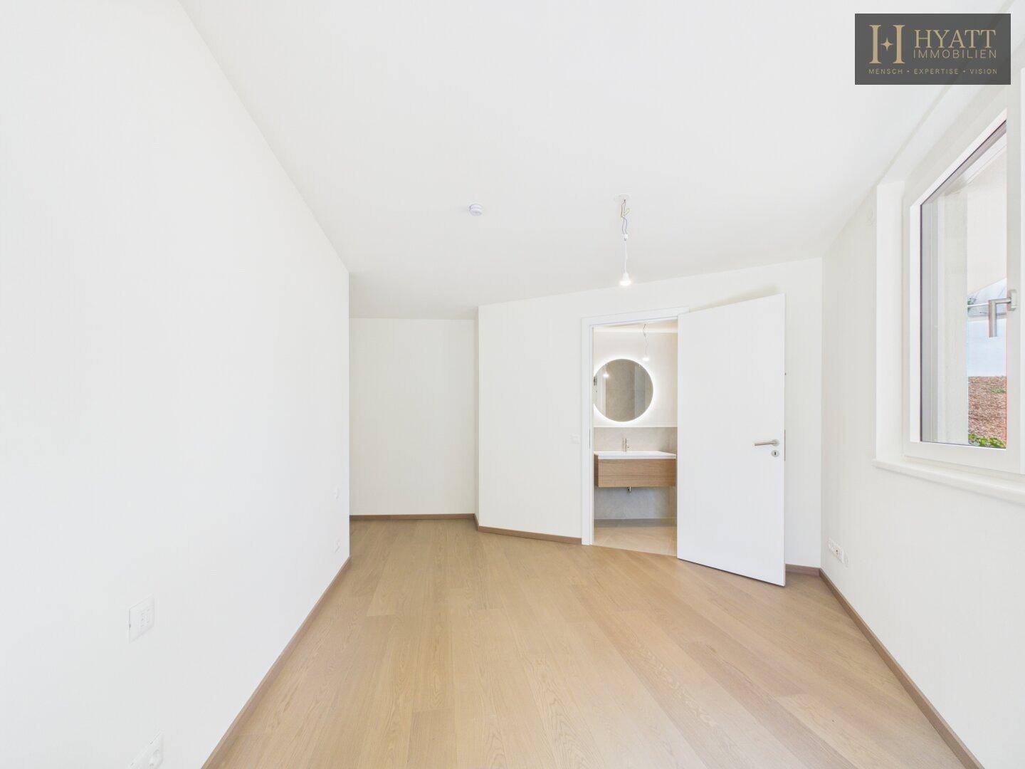 Helles, unmöbliertes Schlafzimmer mit Zugang zu einem privaten Badezimmer.