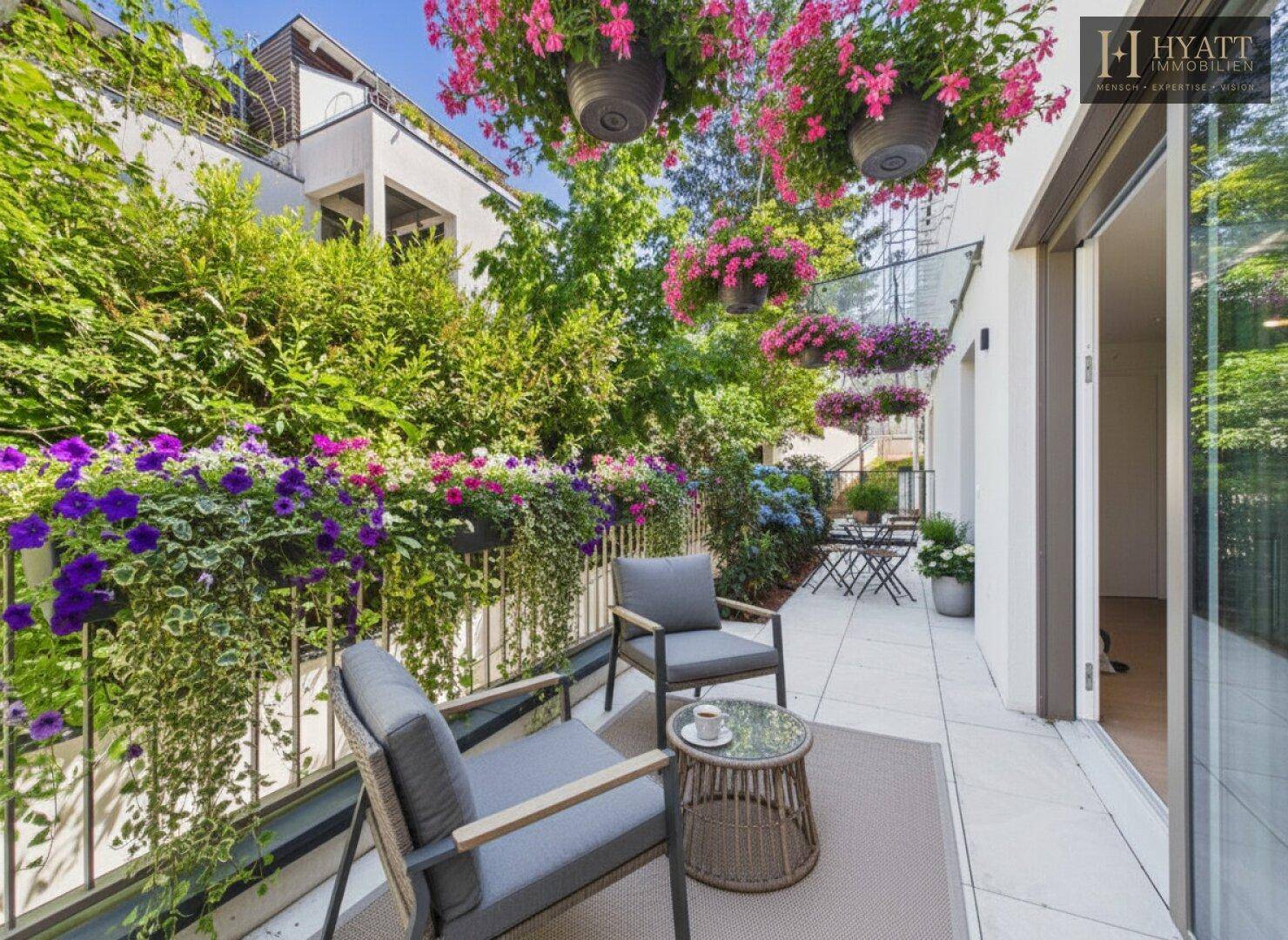 Möblierte Terrasse mit üppiger Bepflanzung und gemütlicher Sitzecke im Freien.