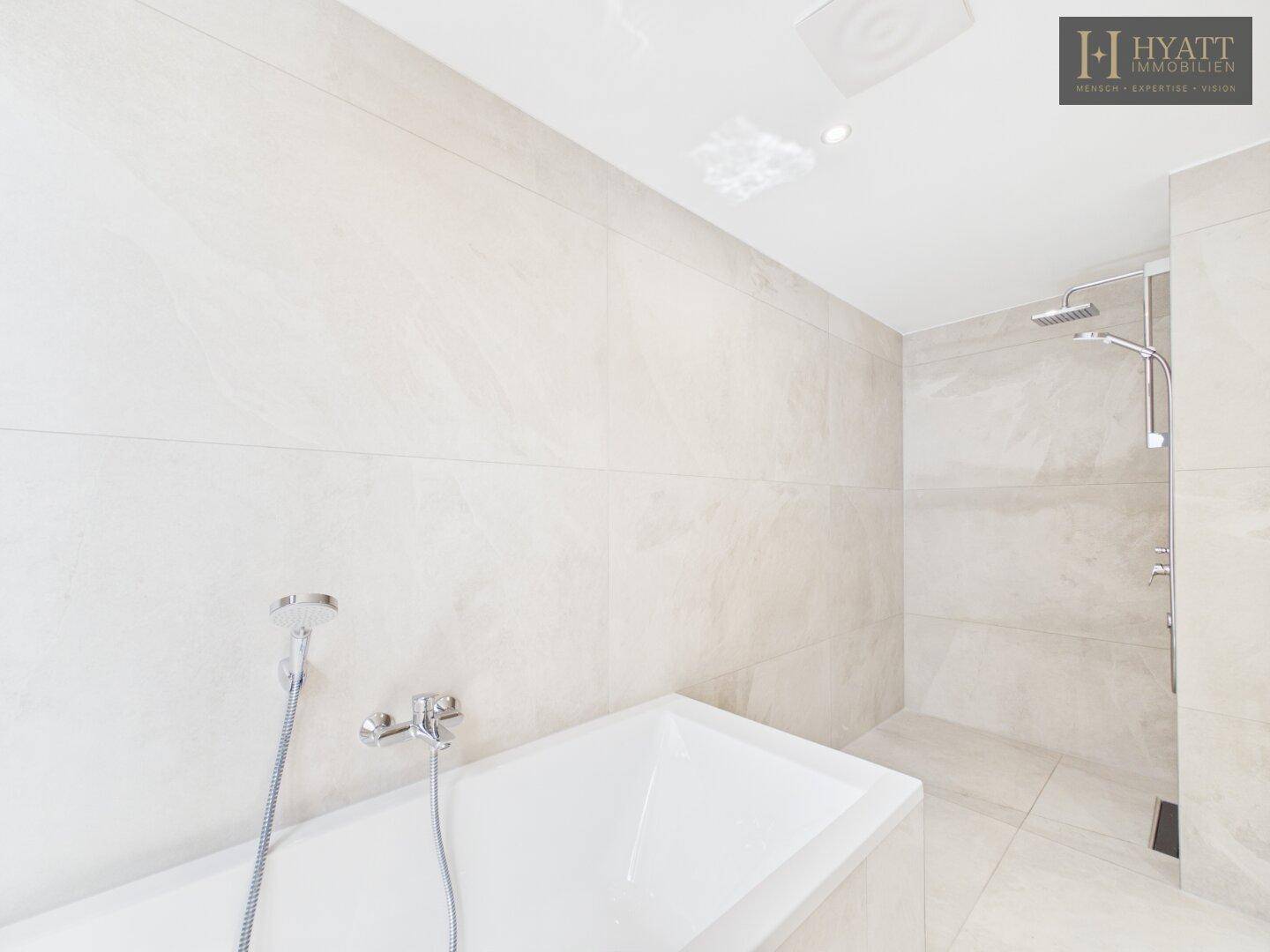 Zeitgemäßes Badezimmer mit Badewanne, integrierter Dusche und hochwertigen Armaturen.