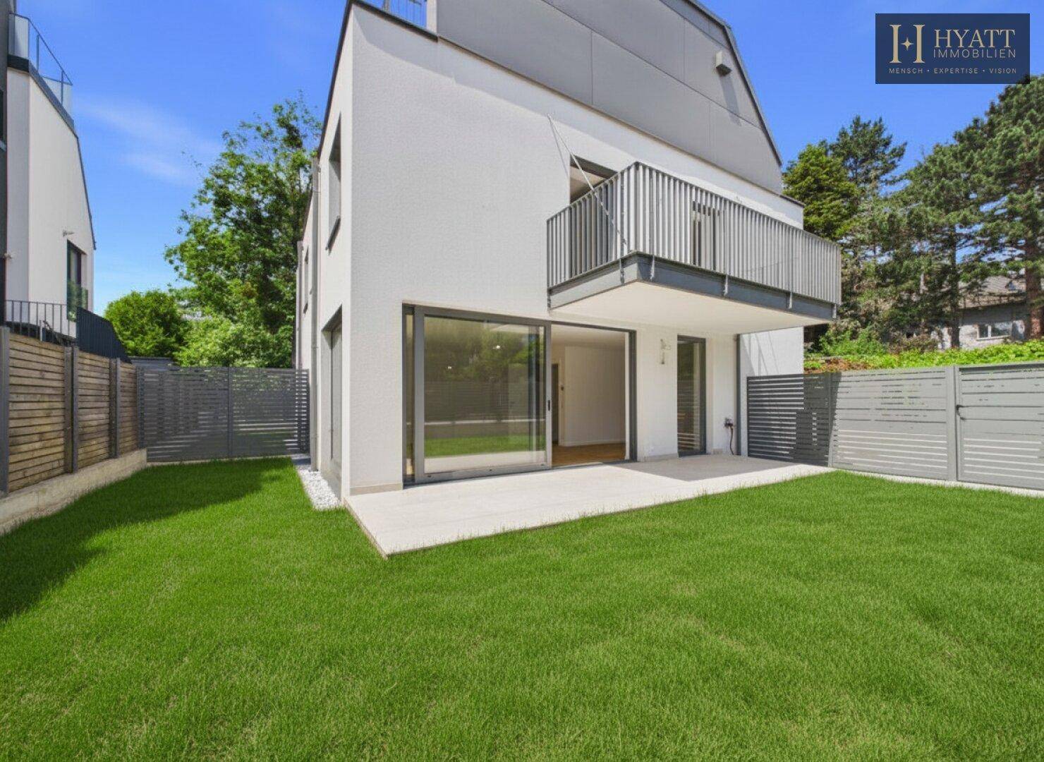 Moderner Neubau mit weißer Fassade, großer Terrasse und privatem Gartenbereich.