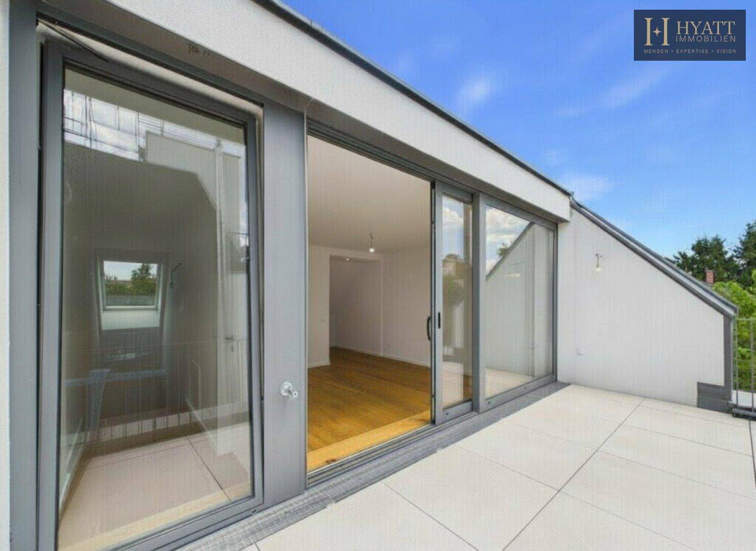 Große Dachterrasse mit Fliesenboden und weitem Blick, ideal für sonnige Stunden.