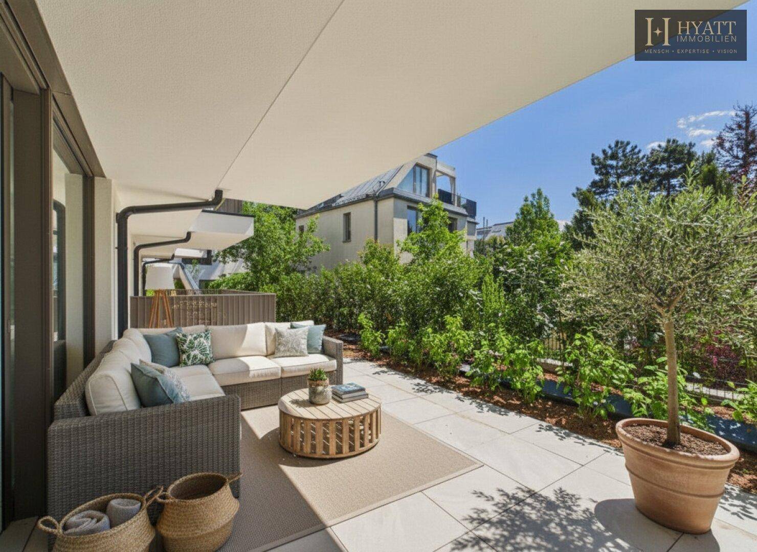 Überdachte Terrasse mit bequemen Gartenmöbeln und Blick auf die grüne Umgebung.