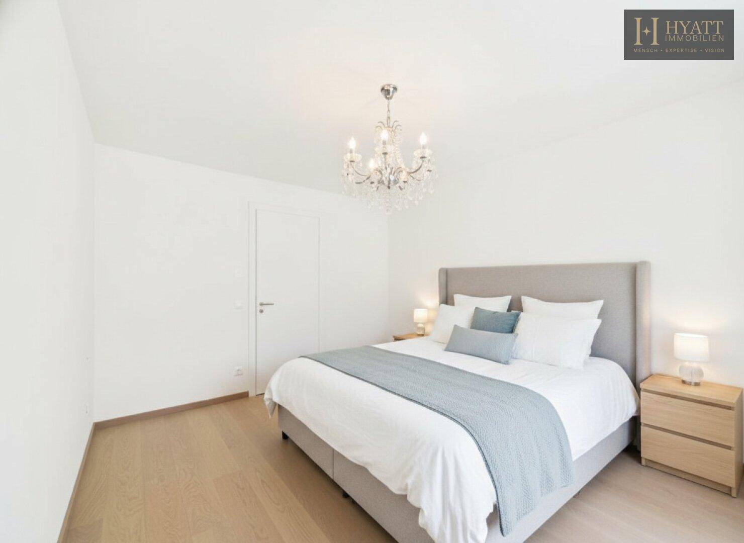 Gemütliches Schlafzimmer mit Doppelbett, Nachttischen und Kronleuchter.