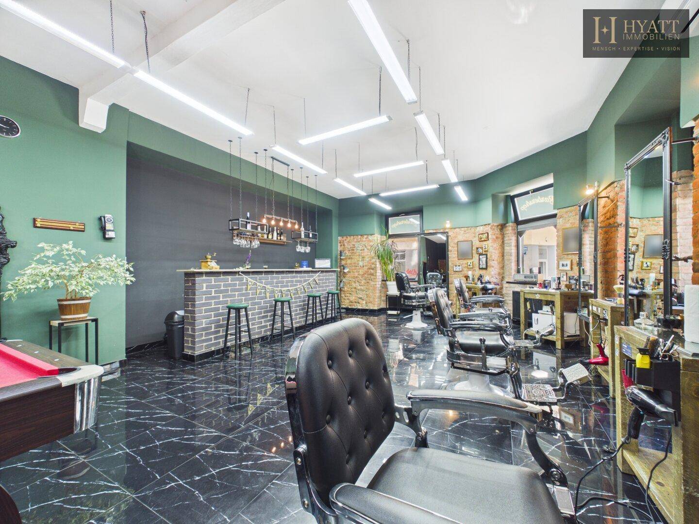 Geräumiger Salon mit Barbereich, Billardtisch und stilvoller Einrichtung für Kunden.