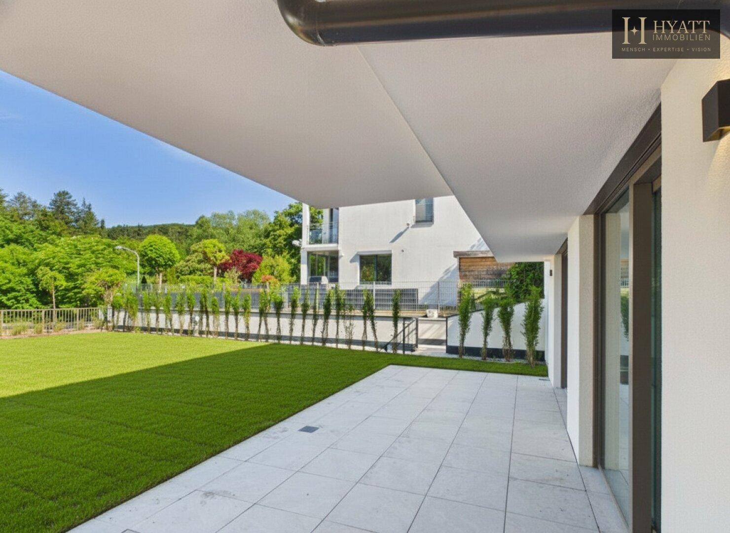 Geräumige Terrasse mit Zugang zum Garten und Blick auf die grüne Umgebung.