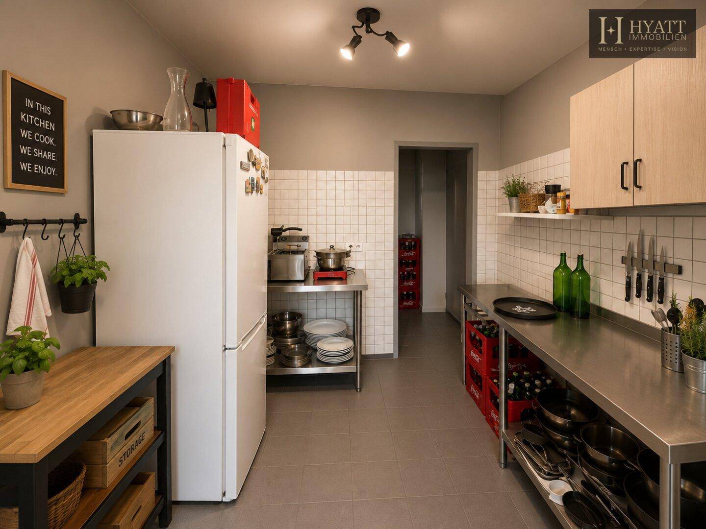 Funktionale Küche mit Edelstahlregalen, großem Kühlschrank und praktischer Arbeitsfläche.