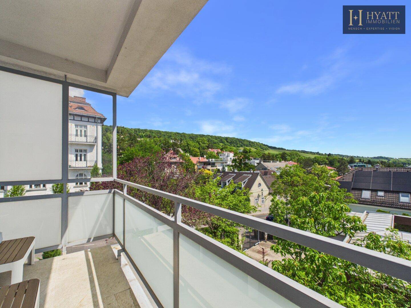 Geräumiger Balkon mit moderner Verglasung und weitem Blick über die grüne Umgebung.