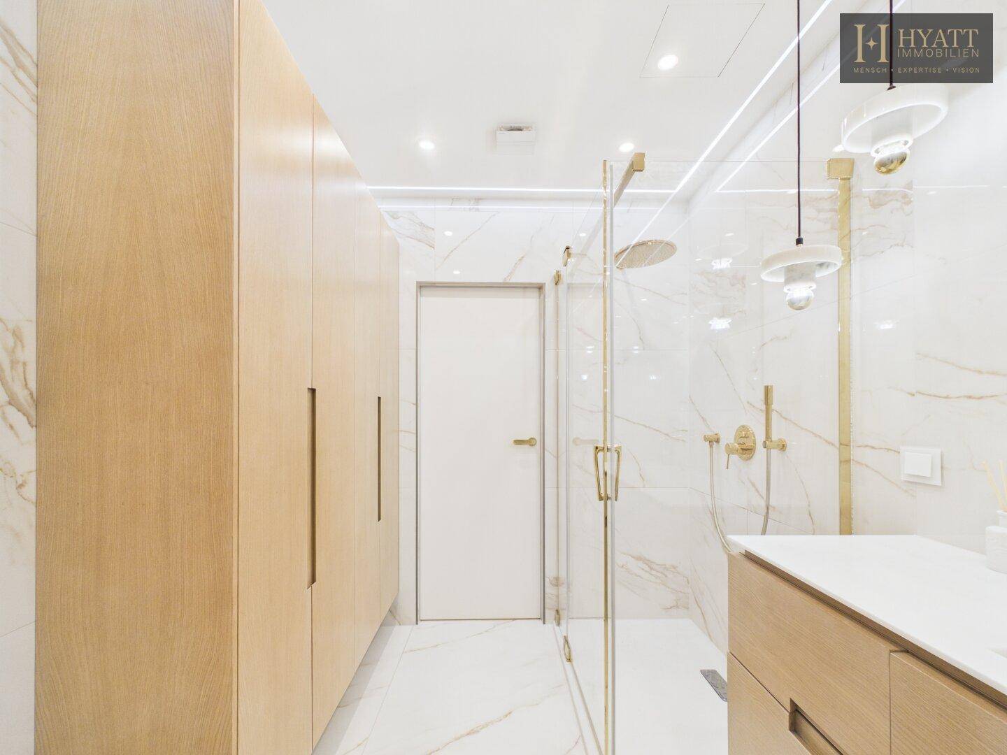Modernes Badezimmer mit begehbarer Dusche, Marmorfliesen und eleganten Holzschränken.