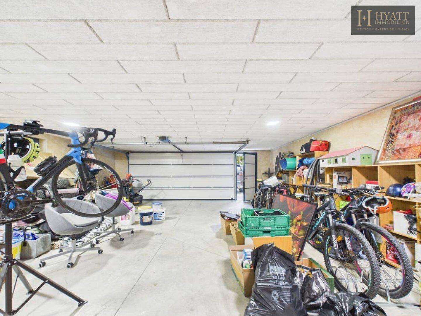 Geräumige Garage mit Fahrrädern und Lagerflächen, die viel Platz bietet.