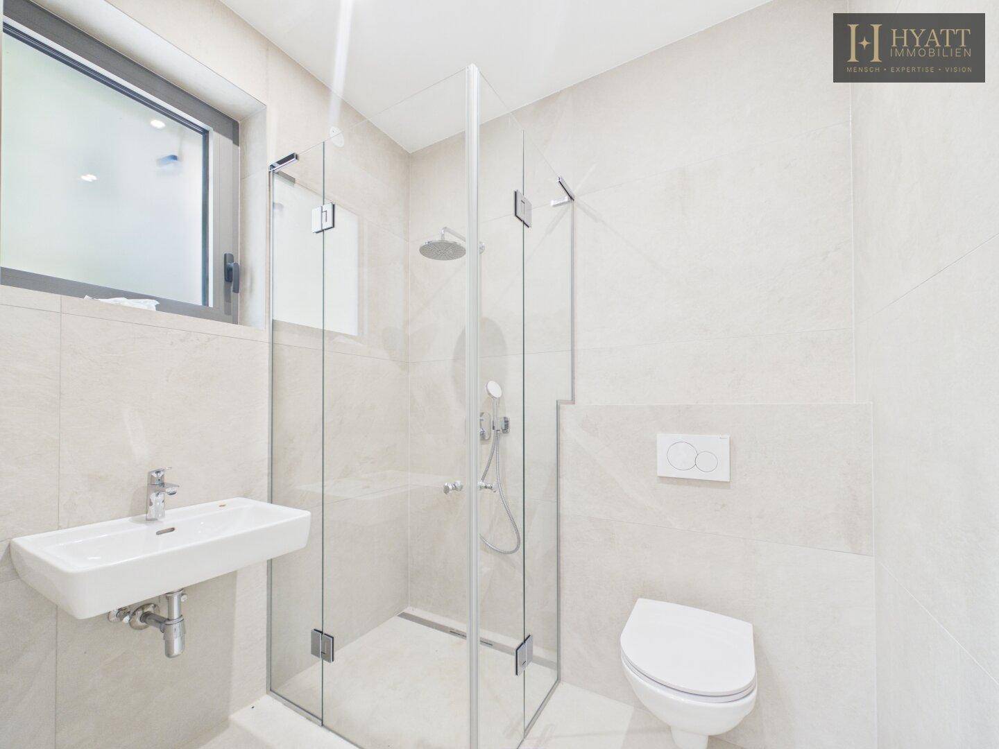 Modernes Badezimmer mit begehbarer Dusche, Wand-WC und hellem Fliesenboden.