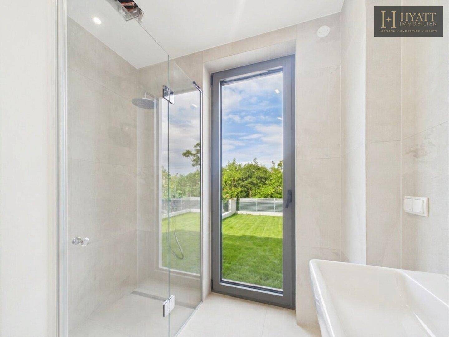 Helles Badezimmer mit begehbarer Dusche, großem Fenster und Blick auf den Garten.