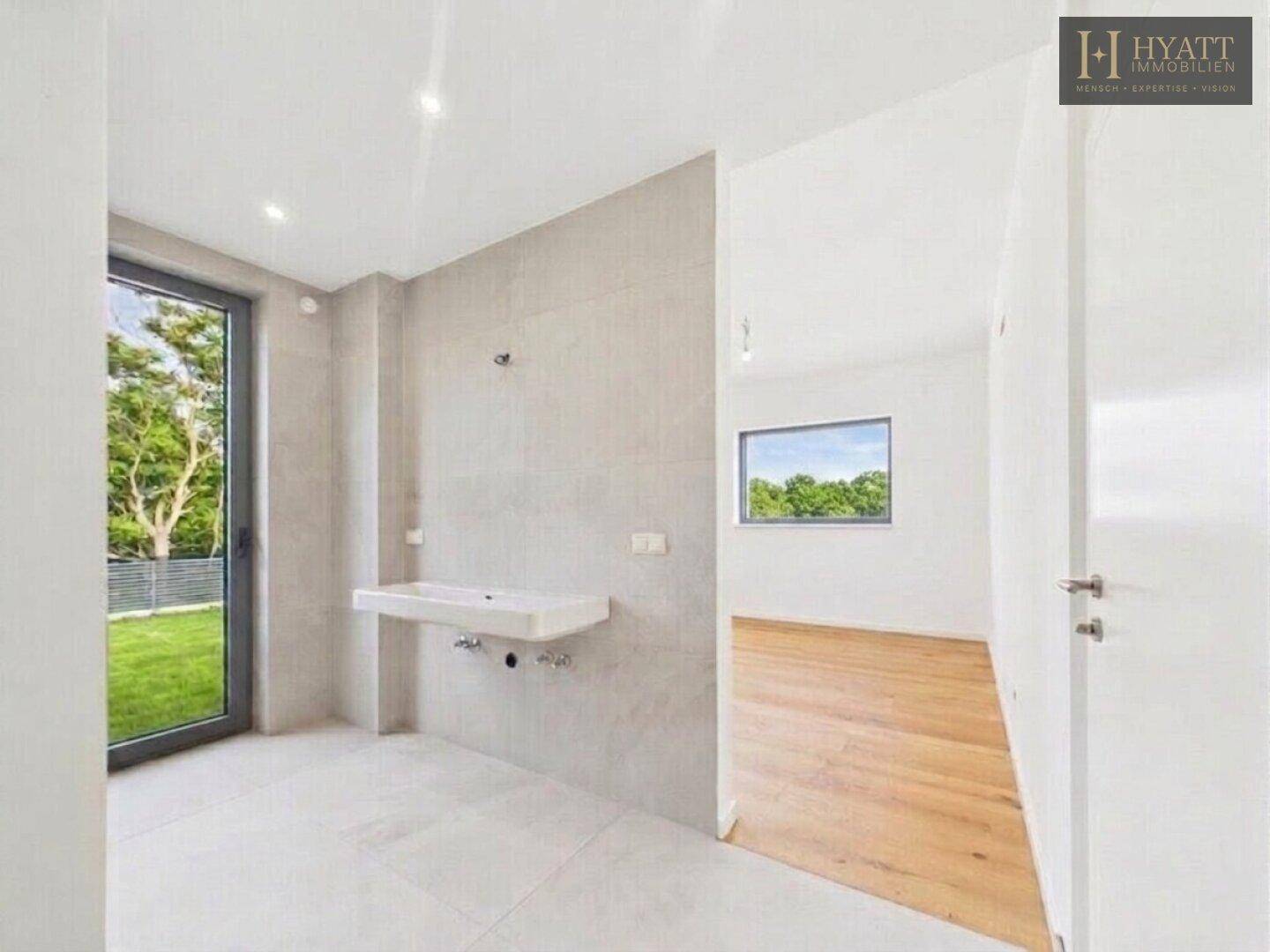 Modernes Badezimmer im Bau mit hellgrauen Fliesen, Wandwaschbecken und großem Fenster.