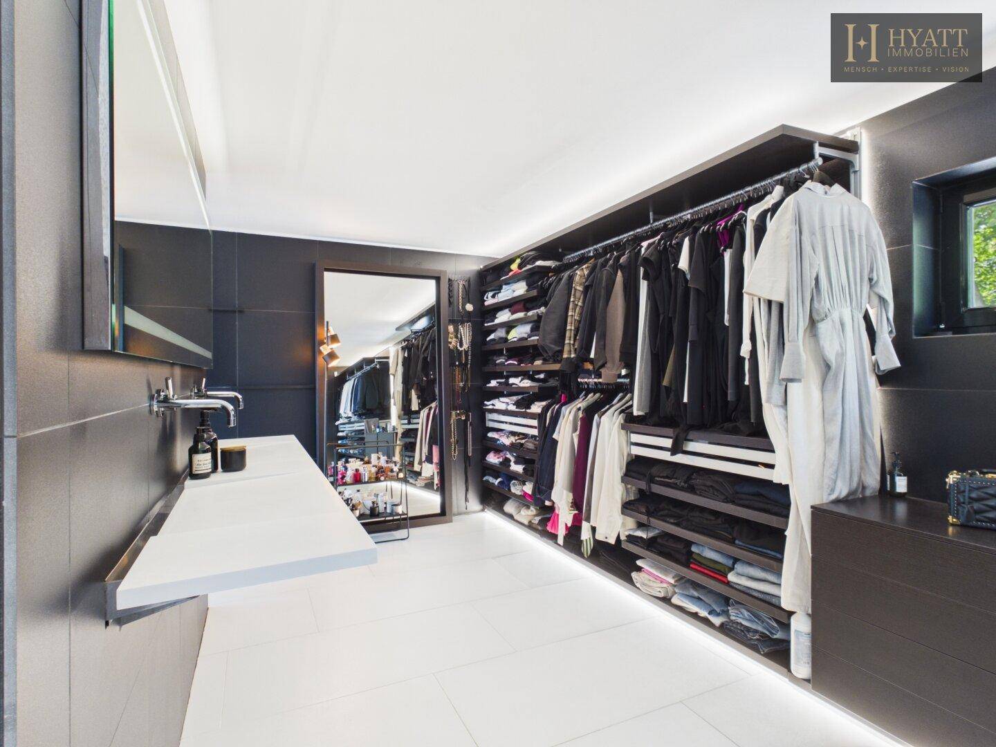 Luxuriöser begehbarer Kleiderschrank mit integriertem Waschtisch und viel Stauraum.