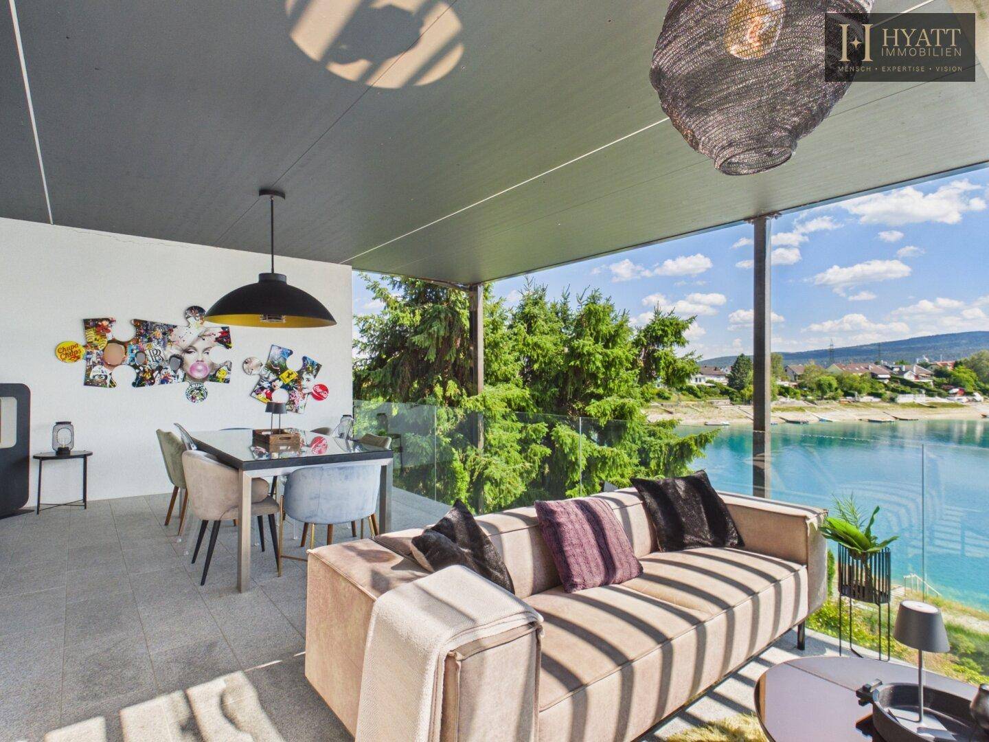 Stilvolle Terrasse mit modernen Möbeln, Essbereich und weitem Blick über den See.