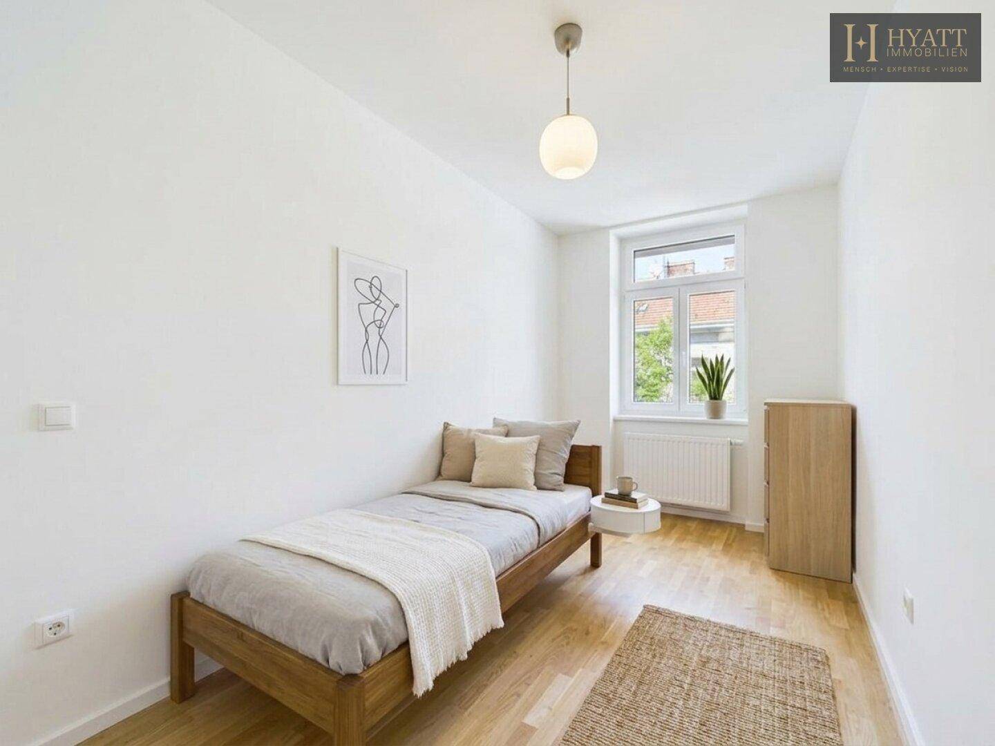 Helles Schlafzimmer mit Einzelbett, Holzboden und einem Fenster, das den Raum gut belichtet.