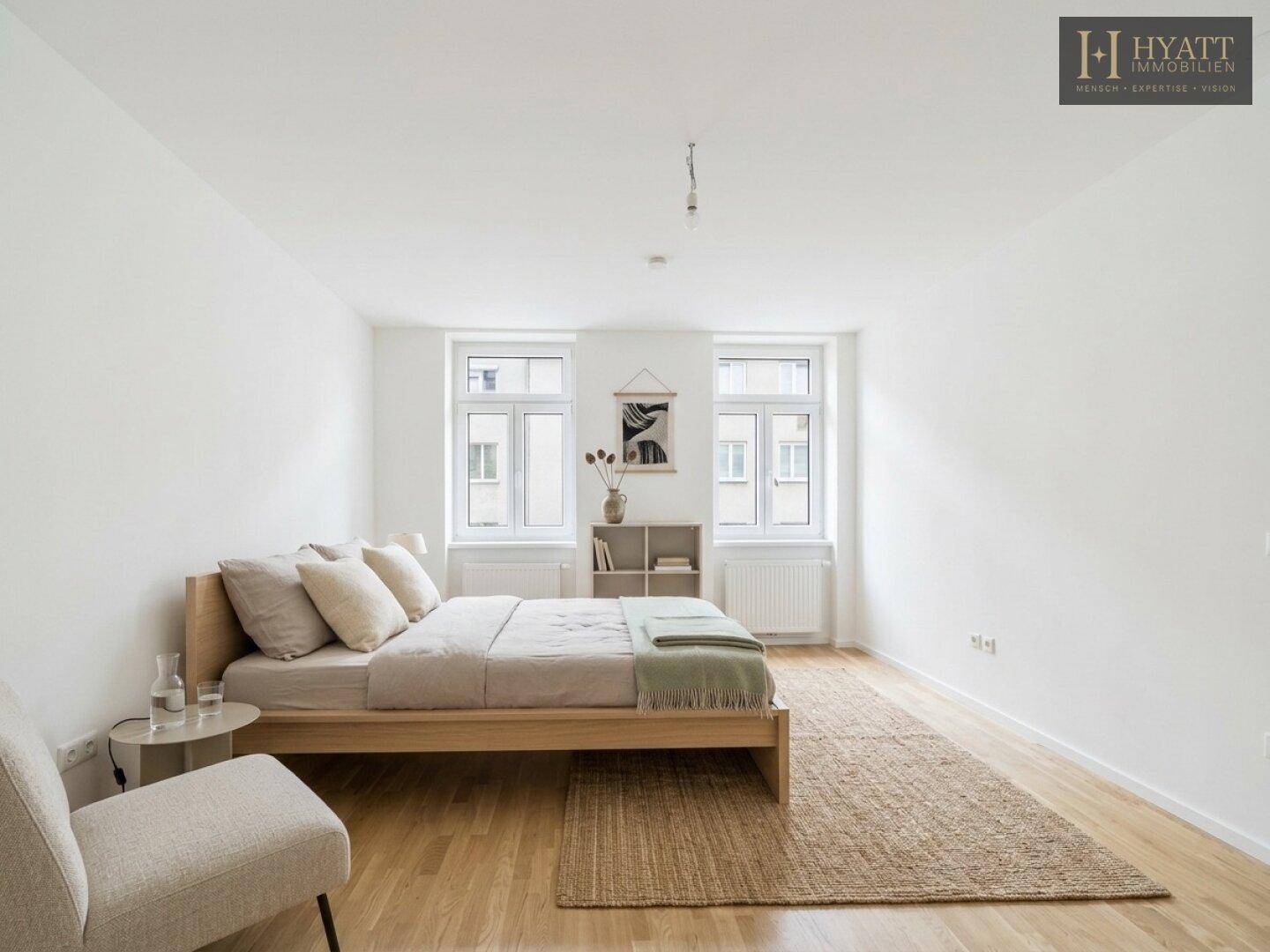 Ruhiges Schlafzimmer mit Holzboden, einem bequemen Bett und Fenstern für natürliche Belichtung.