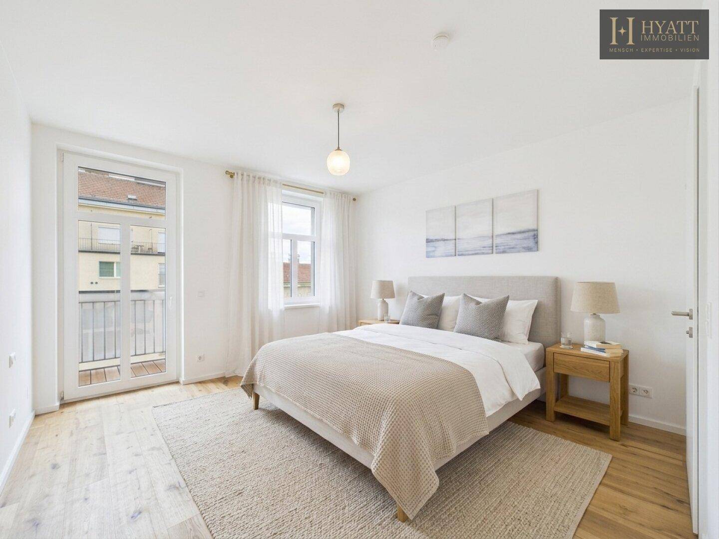 Helles Schlafzimmer mit Doppelbett, Holzboden und Zugang zu einem französischen Balkon.