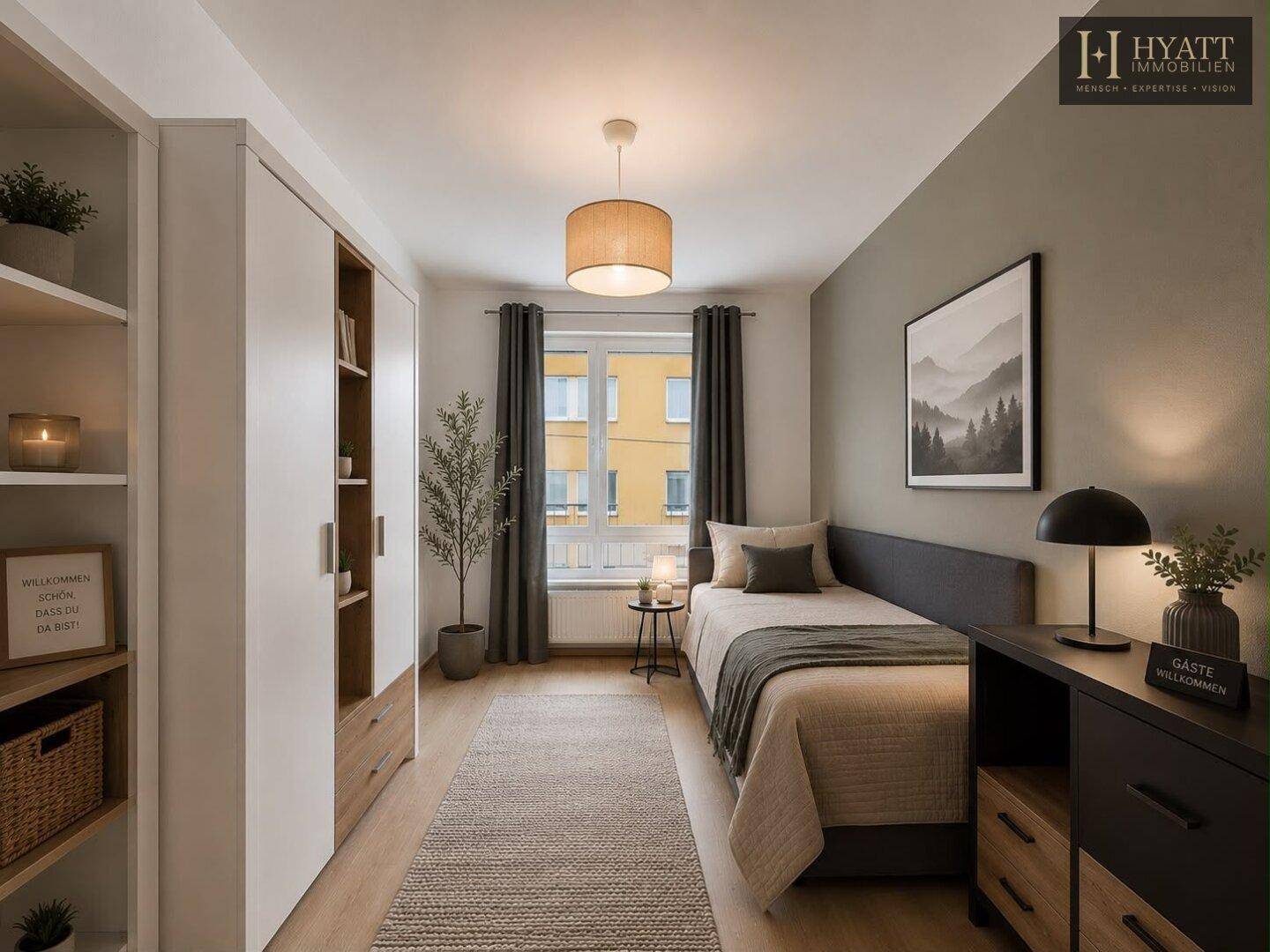 Helles Schlafzimmer mit Einzelbett, Kleiderschrank und Blick aus dem Fenster.