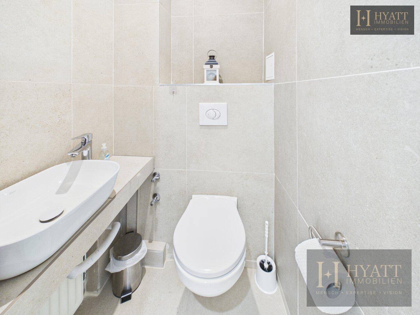 Modernes Gäste-WC mit wandhängendem WC und stilvollem Waschbecken.
