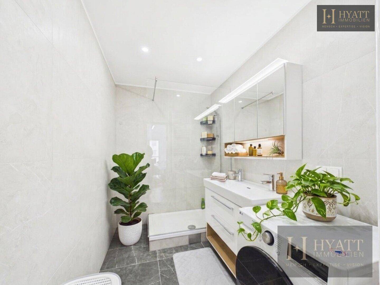 Modernes Badezimmer mit Dusche, Waschbecken und Waschmaschine.
