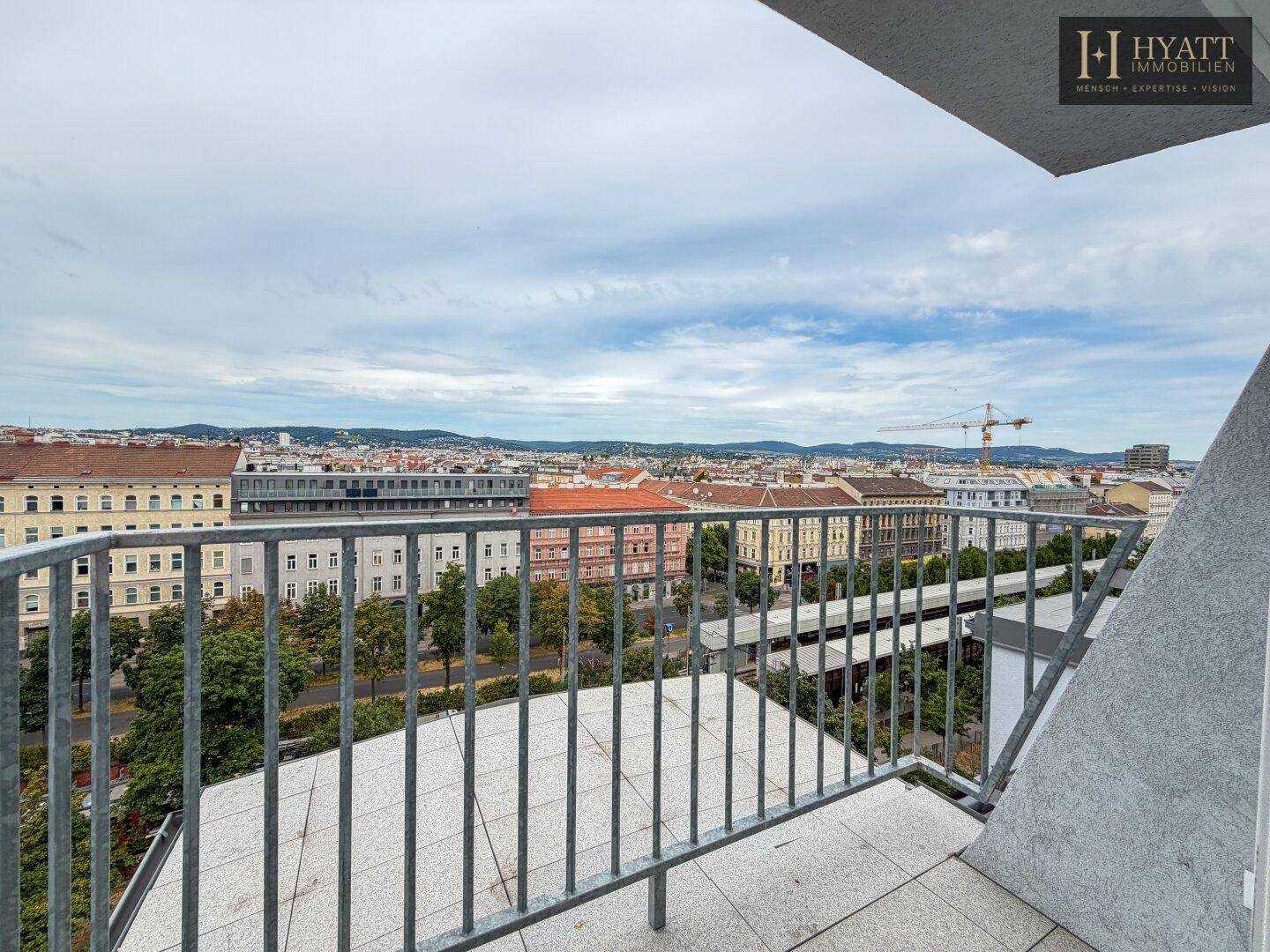 Balkon mit Metallgeländer und weitem Panoramablick über die Stadtlandschaft.