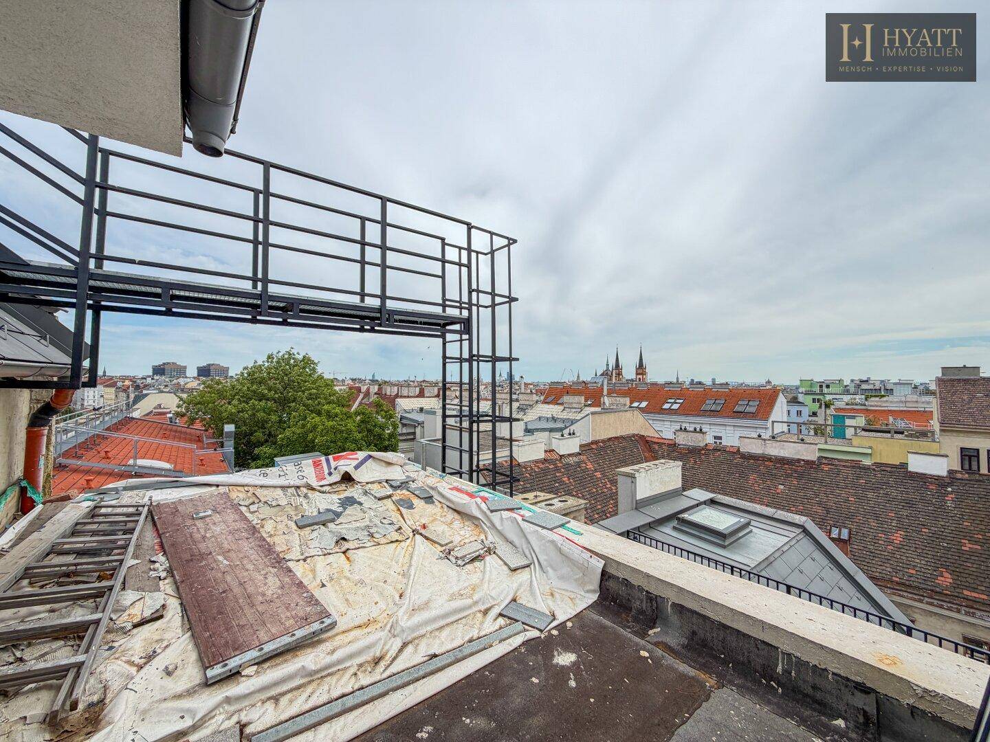 Blick über die Dächer der Stadt mit einer Baustelle im Vordergrund.