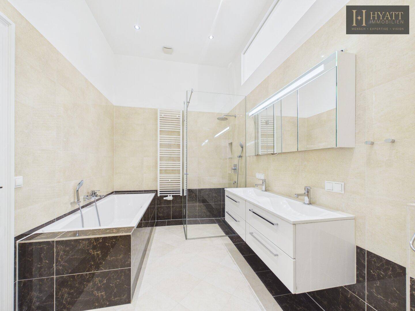 Modernes Badezimmer mit Doppelwaschbecken, Badewanne, begehbarer Dusche und Fliesenboden.