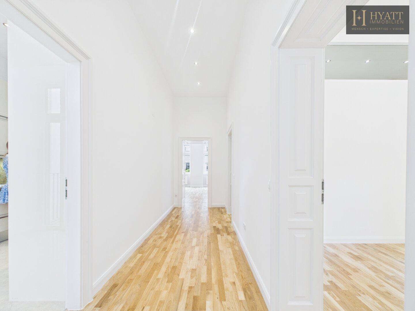Heller Flur mit Parkettboden und Einbauschränken, der zu den Wohnbereichen führt.