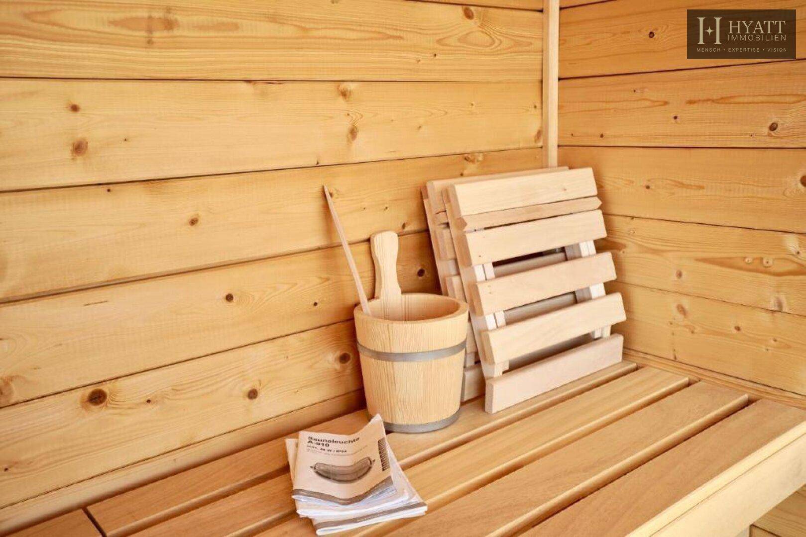 Traditionelle Holzsauna mit Bänken und Zubehör für entspannende Momente.