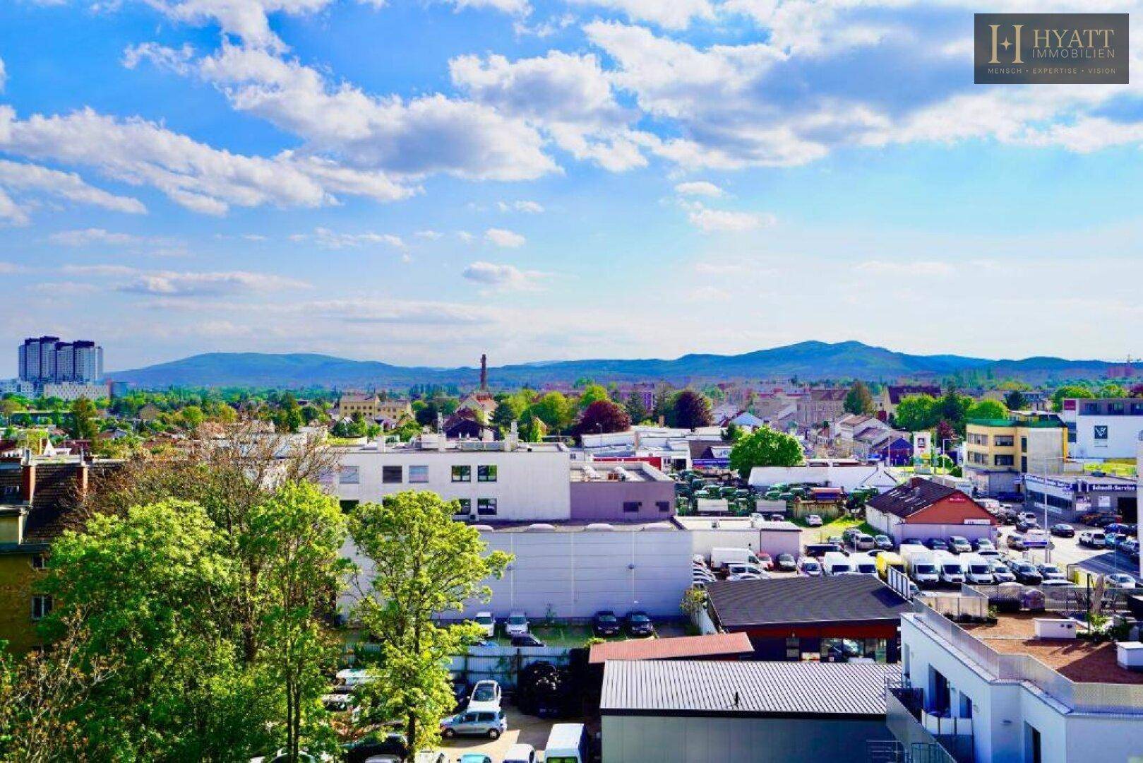 Weitläufiger Panoramablick über die Stadt und die umliegende Berglandschaft.