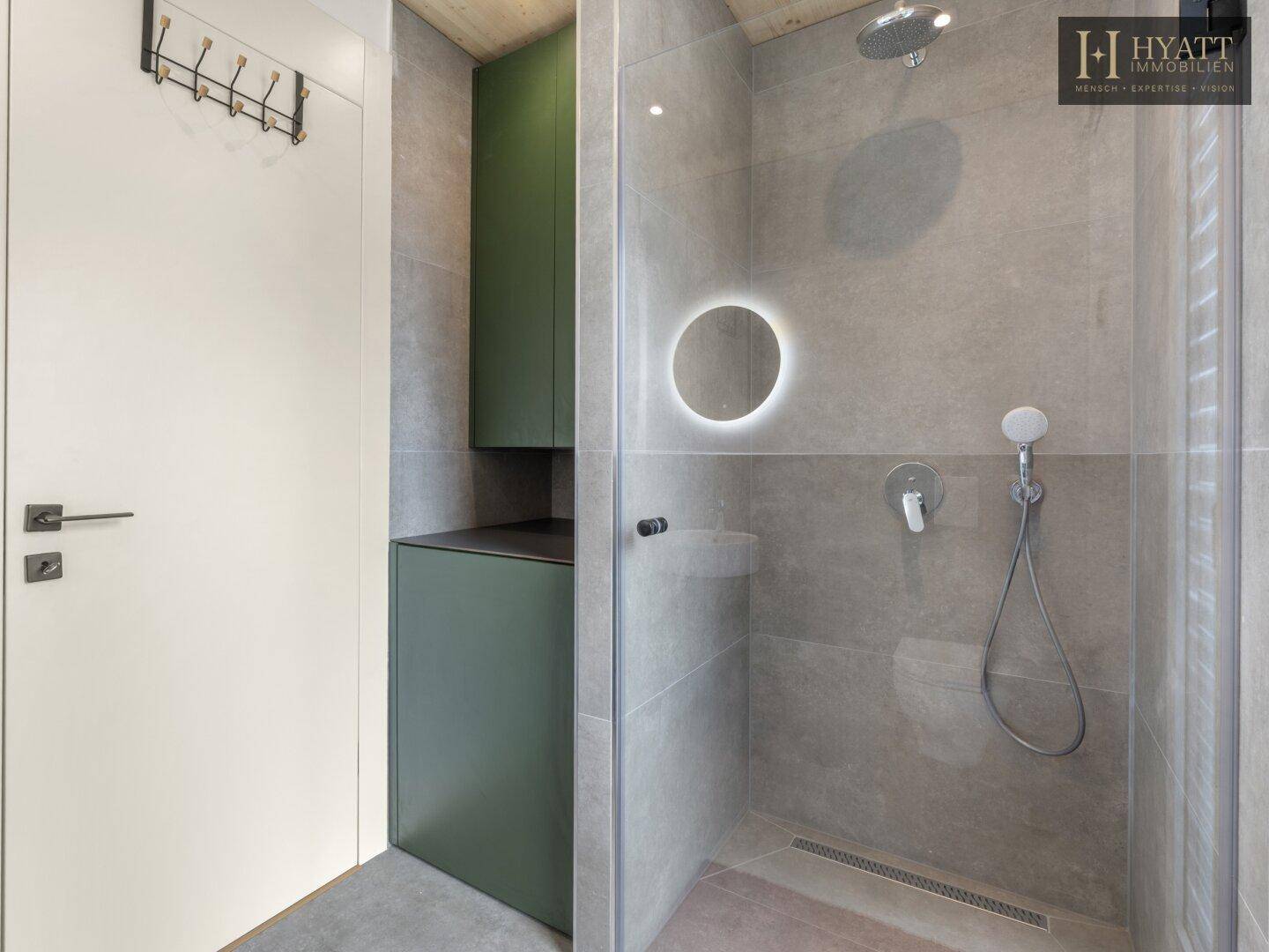 Modernes Badezimmer mit ebenerdiger Dusche, grauen Fliesen und minimalistischem Design.