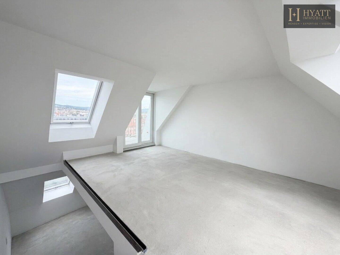 Unmöblierte Galerie im Rohbau mit Dachfenster und Blick auf den unteren Bereich.