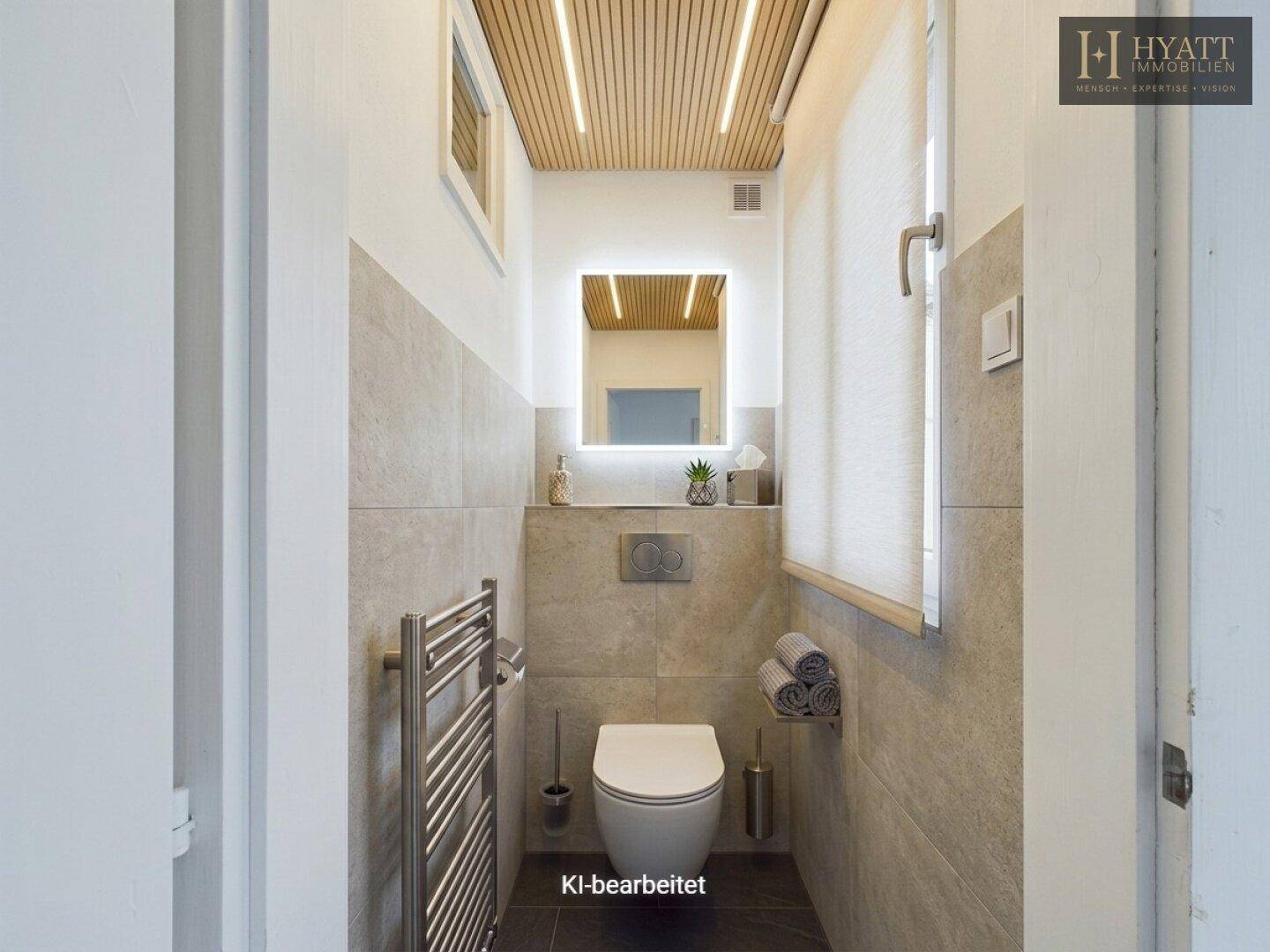 Modernes Gäste-WC mit grauen Fliesen, wandhängendem WC und beheiztem Handtuchhalter.