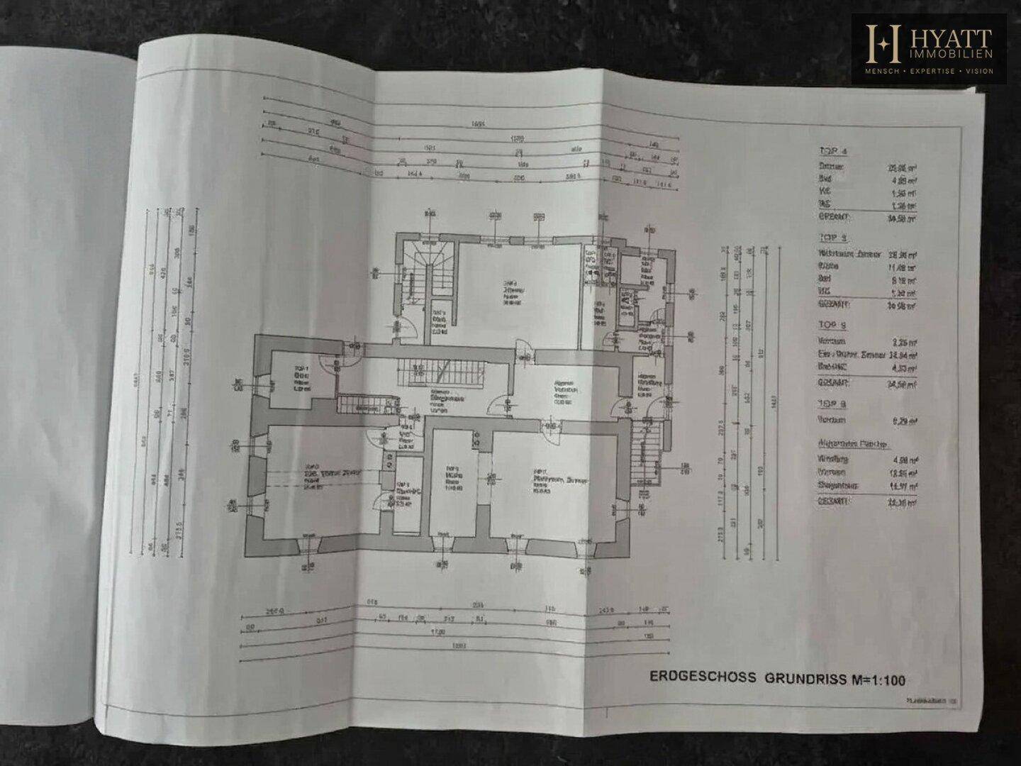 Detaillierter Grundriss des Erdgeschosses mit verschiedenen Räumen und Maßangaben für zwei Einheiten.